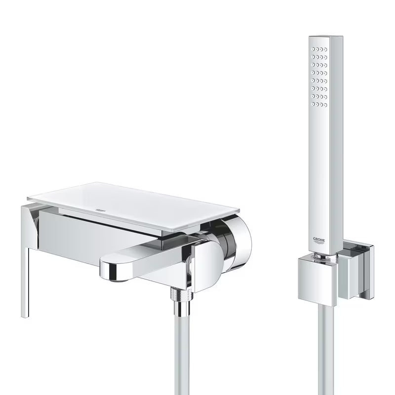 Chromowana ścienna bateria wannowa Grohe Plus z zestawem prysznicowym z dźwignią.