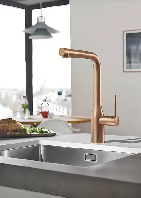 Bateria zlewozmywakowa Grohe Essence New z wysoką obrotową wylewką i wyciąganą wylewką natryskową w wykończeniu brushed warm sunset.