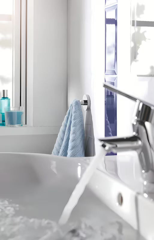 Chromowany haczyk na szlafrok Grohe Essentials z ukrytym mocowaniem na okrągłej rozecie ściennej.