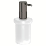Dozownik do Mydła Grohe Essentials bez uchwytu w wykończeniu hard graphite, szklany pojemnik i metalowe elementy.