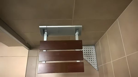 Składane siedzisko prysznicowe Multi w brązowym wykończeniu z litego drewna Bulletwood z uchwytem ściennym.