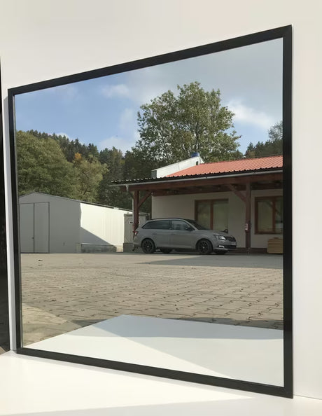 Łazienkowe lustro Naturel z czarną aluminiową ramą o wymiarach 80 x 80 cm.