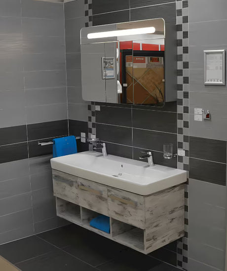 Szafka lustrzana Naturel 100x65 cm w kolorze szaro-srebrnym z trojgiem lustrzanych drzwiczek i oświetleniem LED.