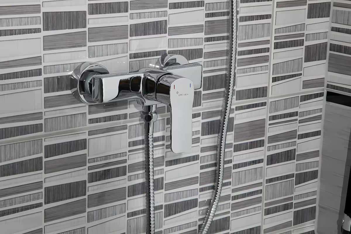 Ścienna jednouchwytowa bateria prysznicowa Optima Cube Way w chromowanym wykończeniu o zaokrąglonym, nowoczesnym designie.