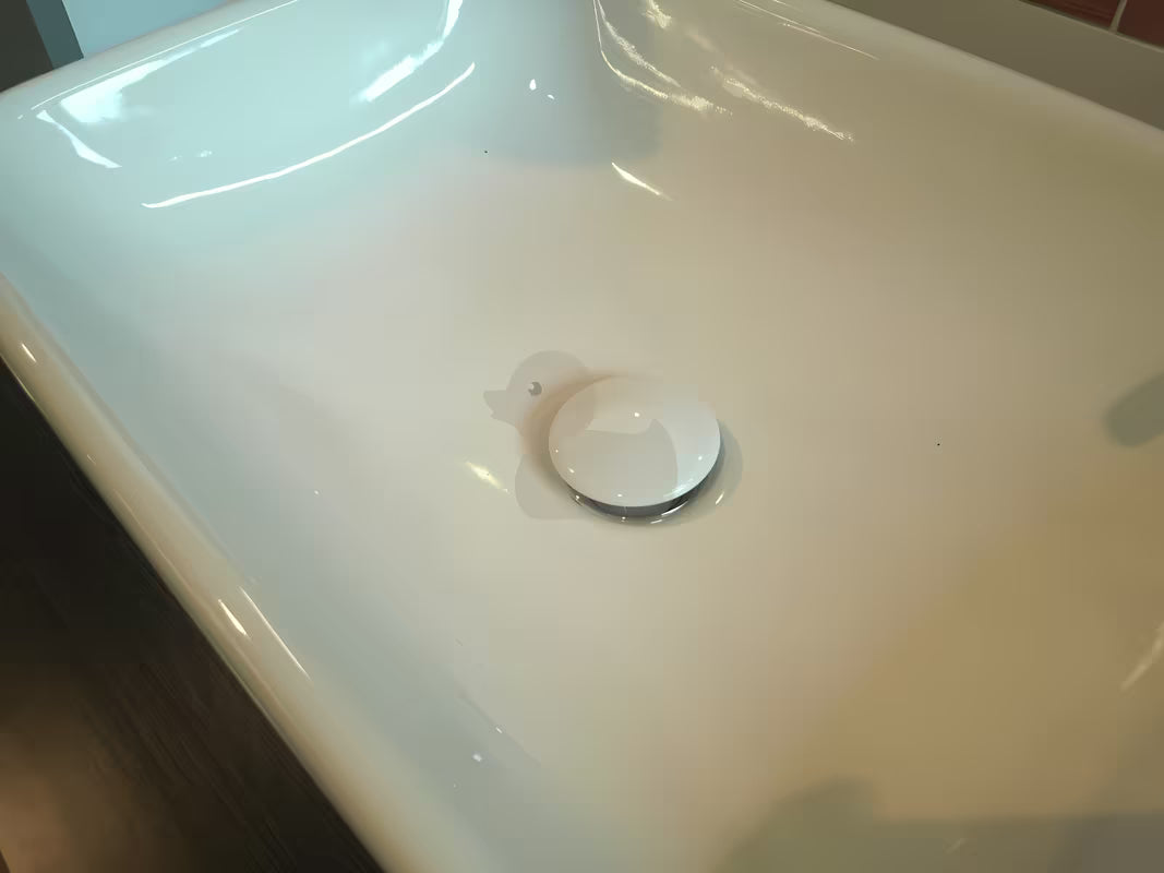 Biała odpływ do umywalki bez przelewu z funkcją stałego przepływu i okrągłym ceramicznym pokrętłem