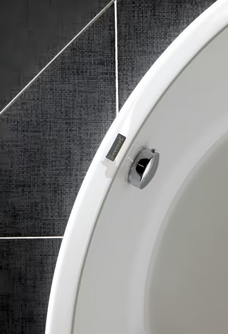 Chromowany automat wannowy o długości 70 cm między przelewem a odpływem oraz z metalowym pokrętłem sterującym.